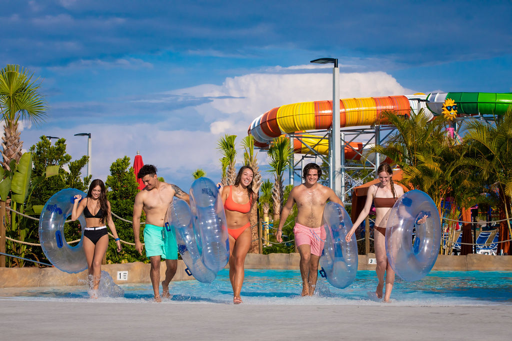 Gruppe junger Erwachsener, die Schläuche im Island H2O Live Water Park tragen.