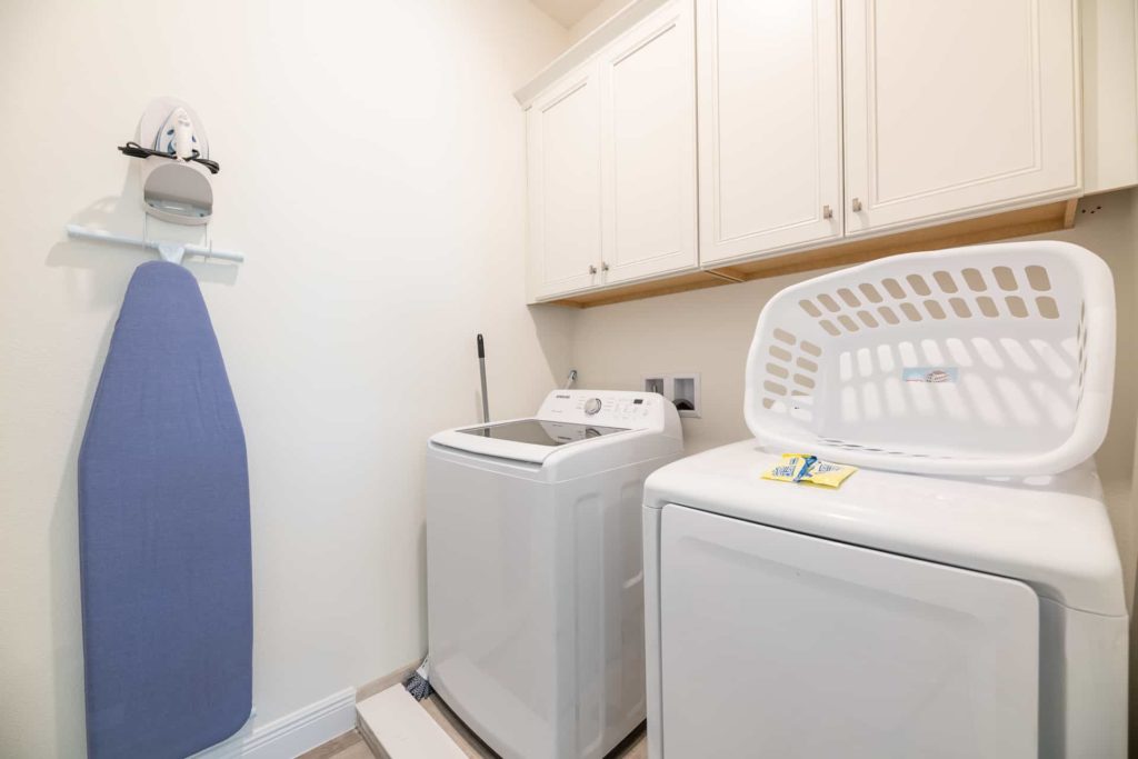 Waschküche mit Waschmaschine, Trockner, Bügeleisen und Bügelbrett: Water's Edge Cottage mit 2 Schlafzimmern