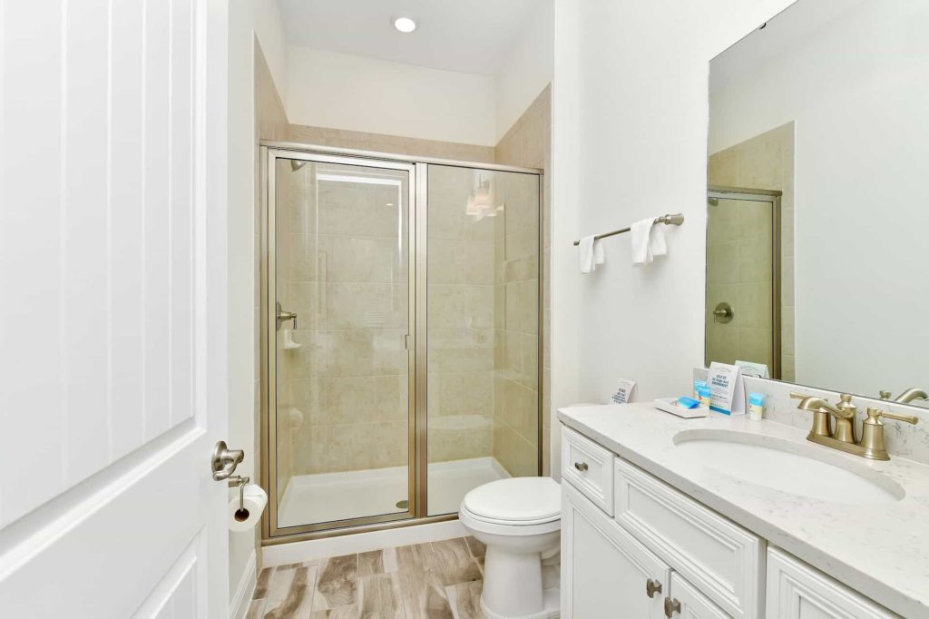 Badezimmer mit ebenerdiger Dusche, Einzelwaschbecken und Spiegel: Water's Edge Cottage mit 3 Schlafzimmern und Pool