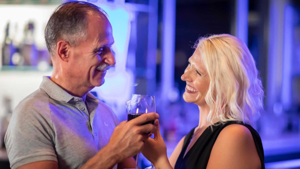 Couple enjoying glasses of wine at Euphoria Lounge | Margaritaville Resort Orlando