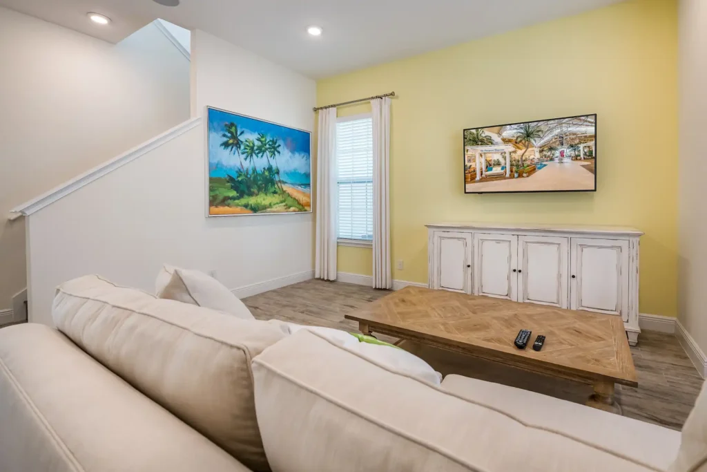Wohnzimmer mit Sofa, wandmontiertem Fernseher und von der Insel inspirierter Wandkunst: Premium Cottage mit 3 Schlafzimmern