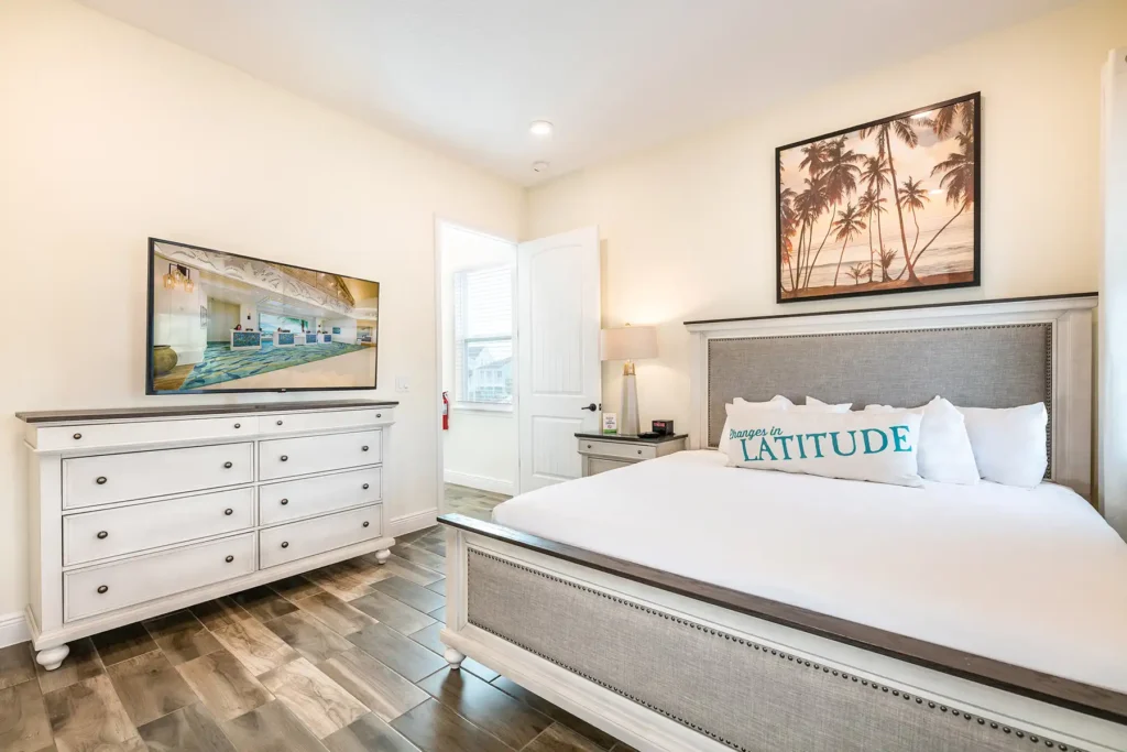 King bedroom with wall-mounted TV and island-inspired wall art: 3 Bedroom Elite Cottage