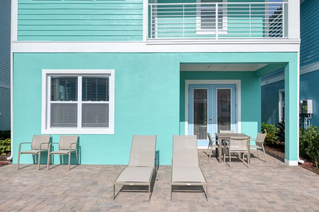 Outdoor patio with overhead balcony and sun loungers: 3 Bedroom Superior Cottage