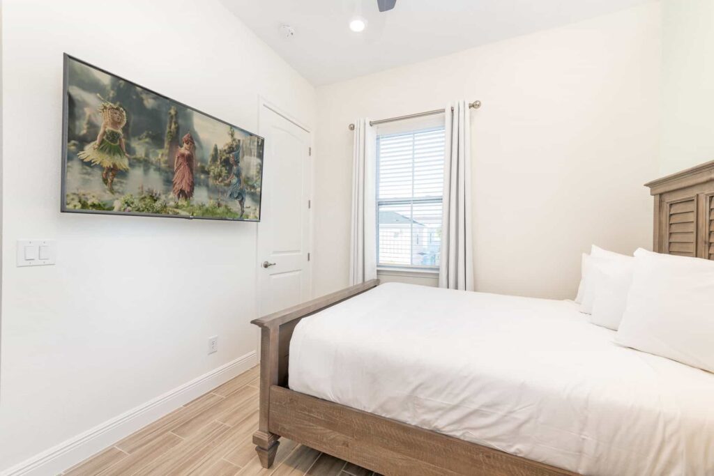 Schlafzimmer 2 mit französischem Bett und an der Wand befestigtem Fernseher: Cottage mit 4 Schlafzimmern