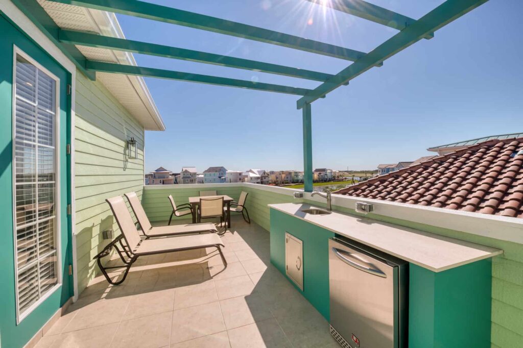 Upper-level outdoor balcony with sun loungers and wet bar: 4 Bedroom Elite Cottage