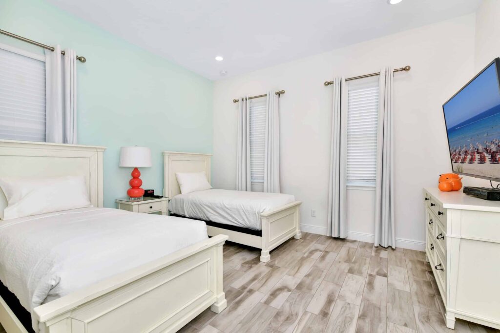 Bedroom 4 with twin single beds and wall-mounted TV: 6 Bedroom Cottage