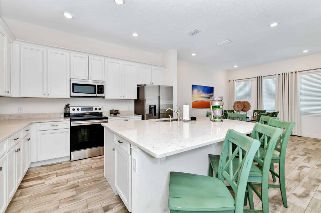 Full kitchen with island sink, barstool seating, oven range, and refrigerator: 6 Bedroom Cottage