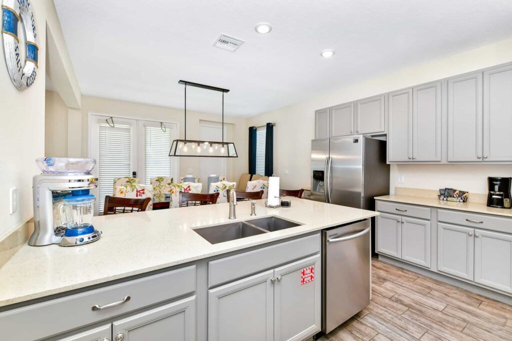Full kitchen and dining area featuring large kitchen island with sink and dishwasher: 7 Bedroom Cottage