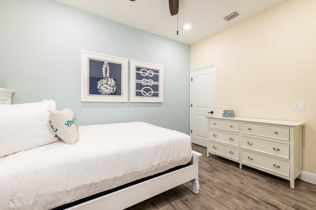 Schlafzimmer 3 mit Queensize-Bett, Kommode und nautisch inspirierter gerahmter Wandkunst: 8-Schlafzimmer-Premium-Cottage