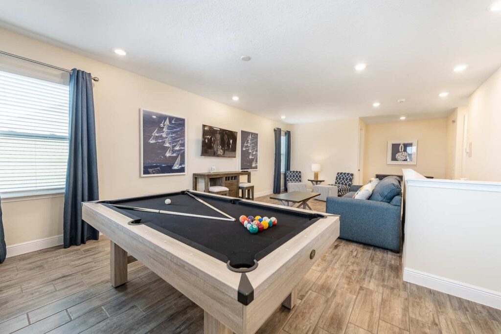Upper-floor loft room with pool table, sofa, and wall-mounted TV: 8 Bedroom Premium Cottage