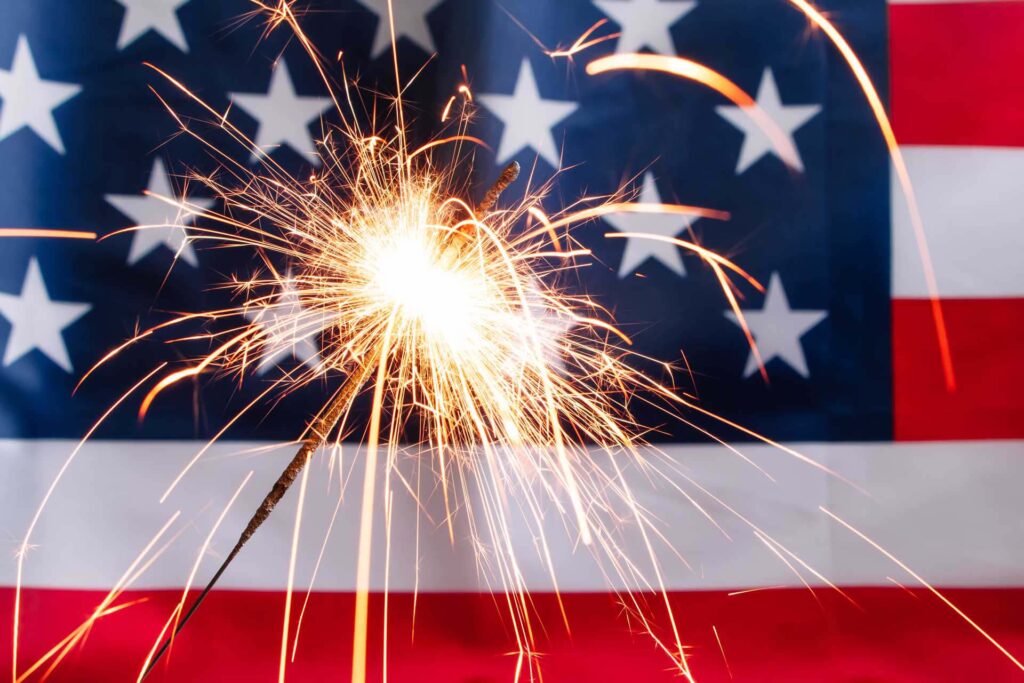 A sparkler in front of the American flag