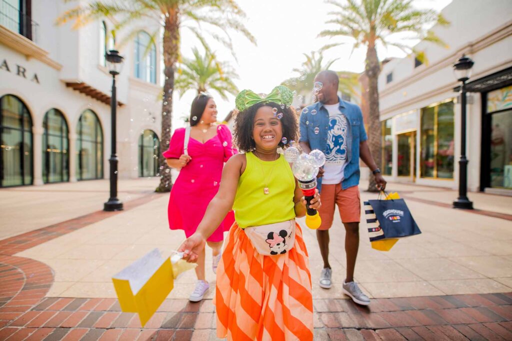 Familia feliz caminando en Disney Springs con bolsas de compras