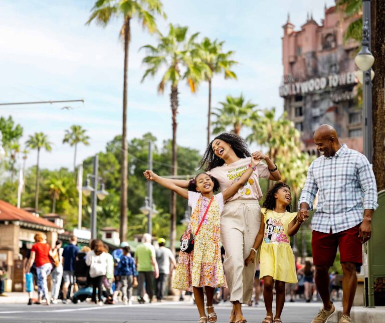 Família feliz andando pela Sunset Boulevard no Disney's Hollywood Studios