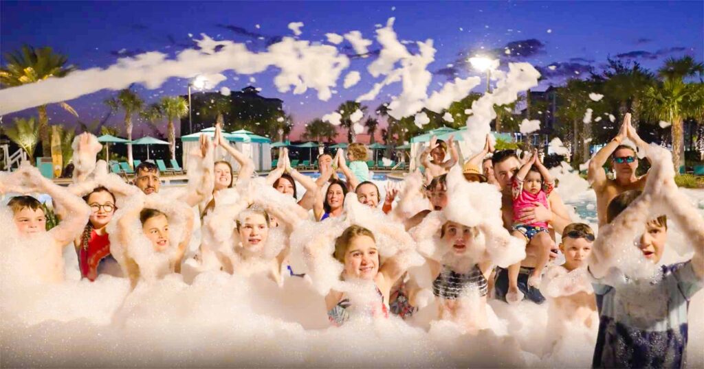 Group of kids in Margaritaville Resort Orlando’s Fins Right Pool covered in foam during a foam party
