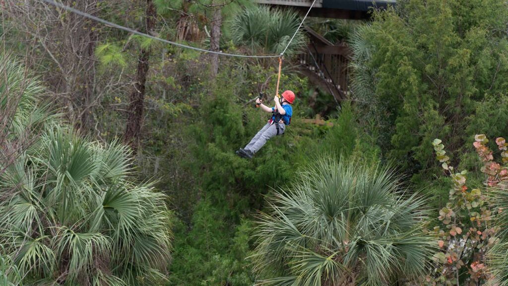 Boy riding on a zipline at Gatorland theme park in Orlando, Florida