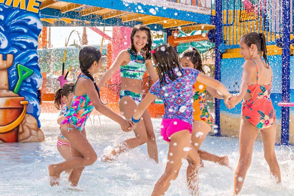 مجموعة من الفتيات الصغيرات يستمتعن ويلعبن في مسبح الأطفال Pelican's Paradise في حديقة Island H2O المائية