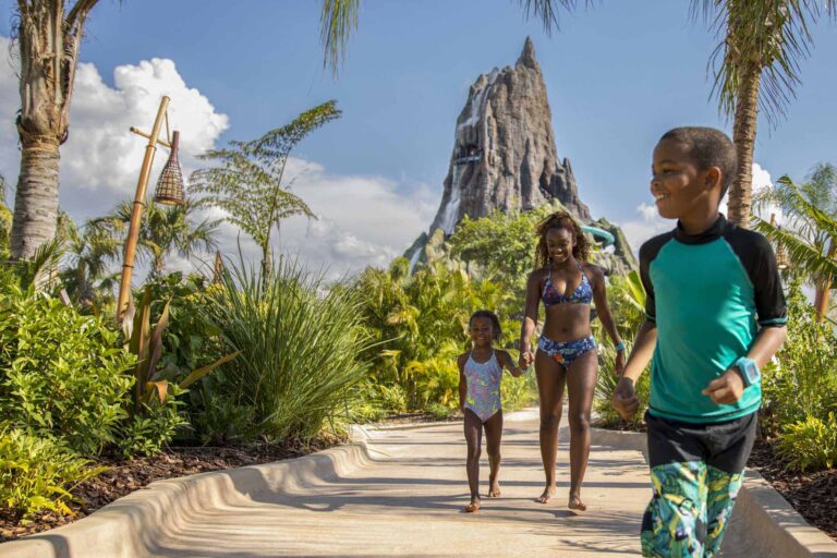 Glückliche Familie spaziert durch den Wasserpark Volcano Bay von Universal