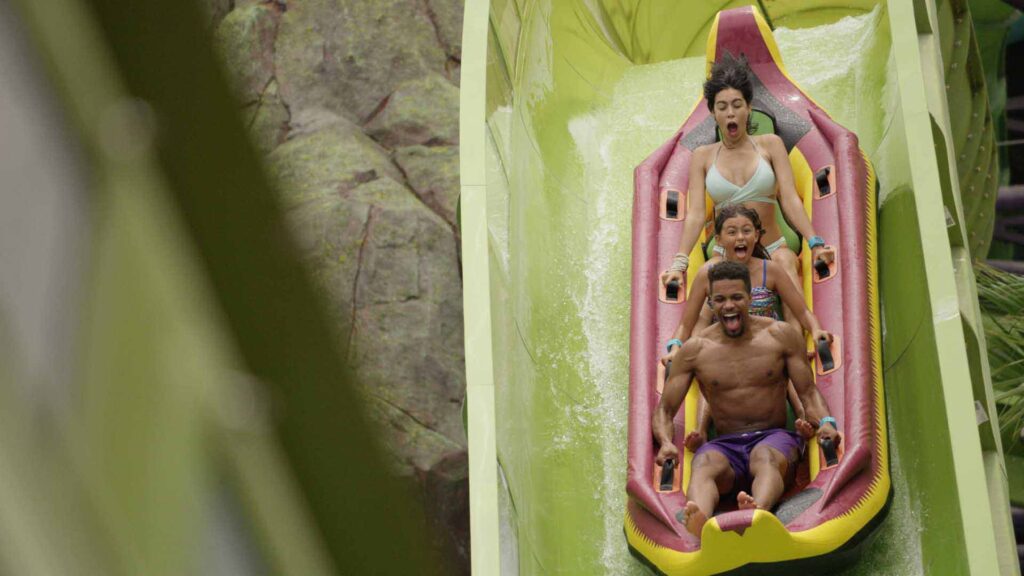 Семья катается на горках Krakatau Aqua Coaster в заливе Вулкан в Юниверсал.