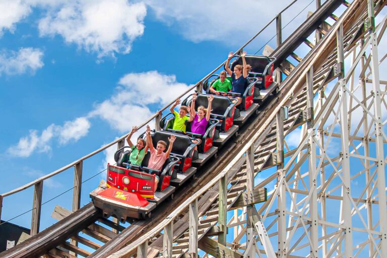 Group of people riding the White Lightning wooden roller coaster at Fun Spot America in Orlando, Florida