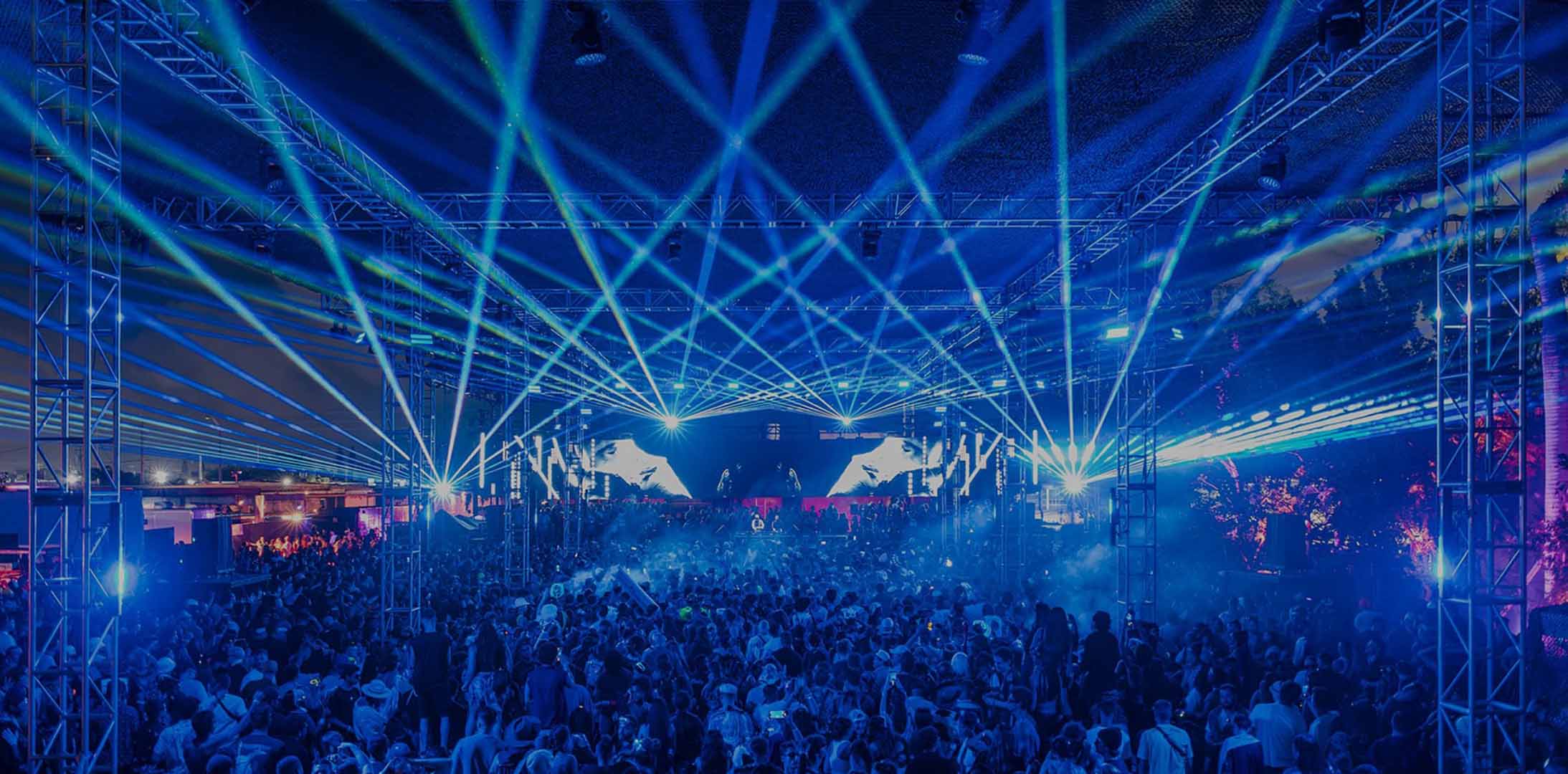 Huge crowd in front of a stage at a concert with blue colored light effects