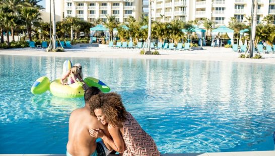 fl-ga-residents Couple hugging and laughing by the pool at Margaritaville Resort Orlando.