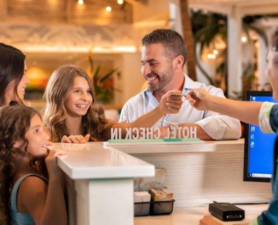 A concierge agent greets a family at the Margaritaville Resort Orlando lobby.